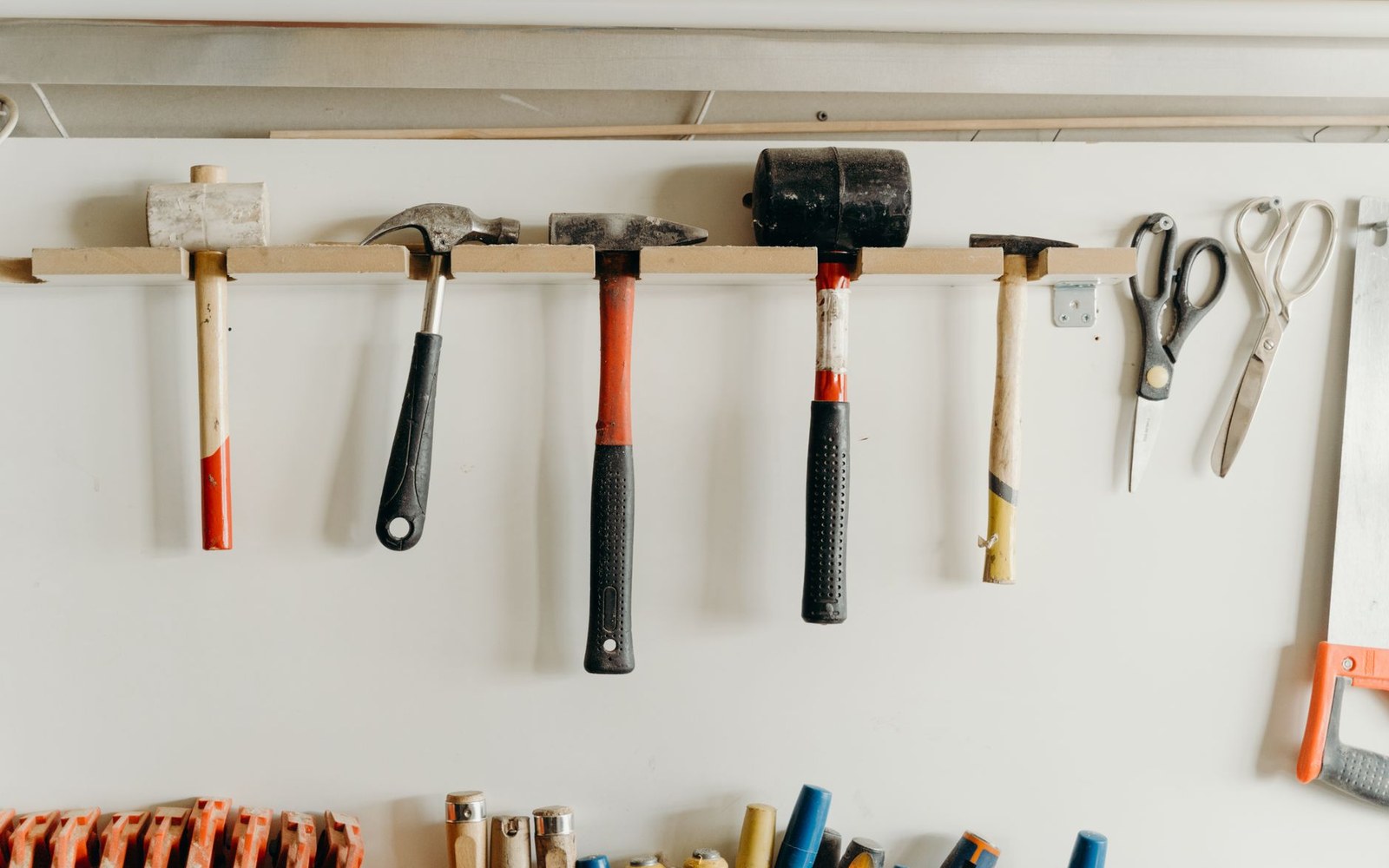 A rank of finished violin bows hanging on a workshop wall rack, tips toward camera